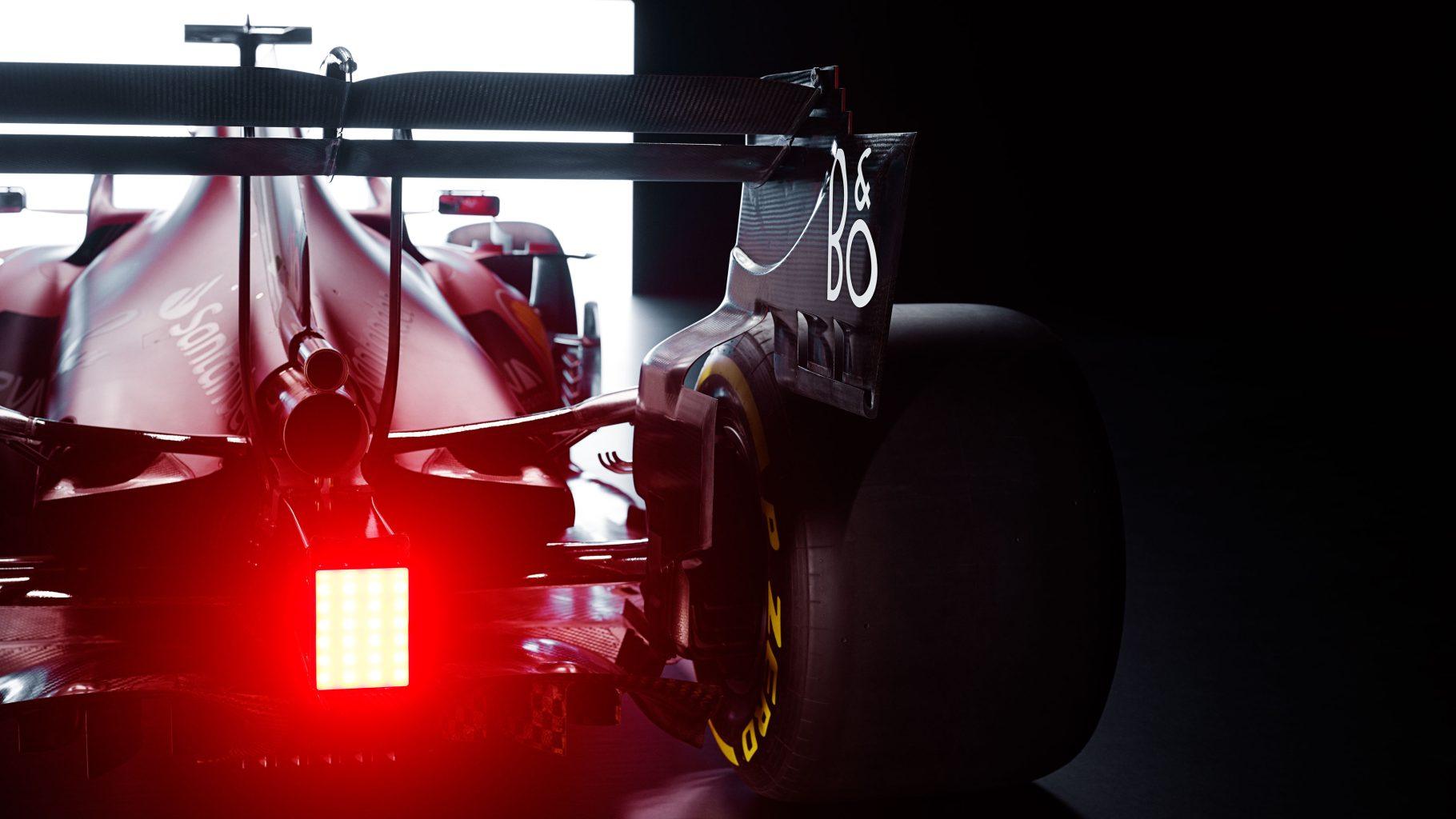Scuderia Ferrari F1 car with Bang & Olufsen logo on the rear wing, photographed under dramatic lighting — symbolizing the official 2023 audio partnership.