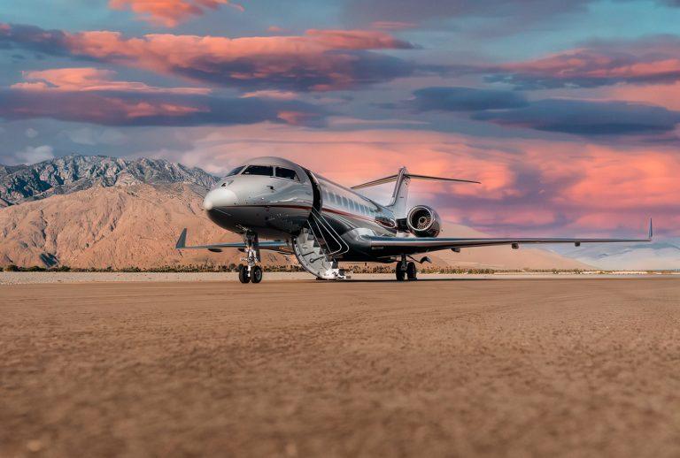 Private jet parked on runway at sunset, Vista Global fleet.