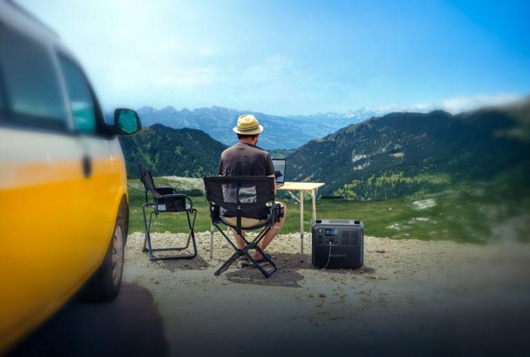 Off-grid creator setup with Bluetti power station overlooking remote mountains