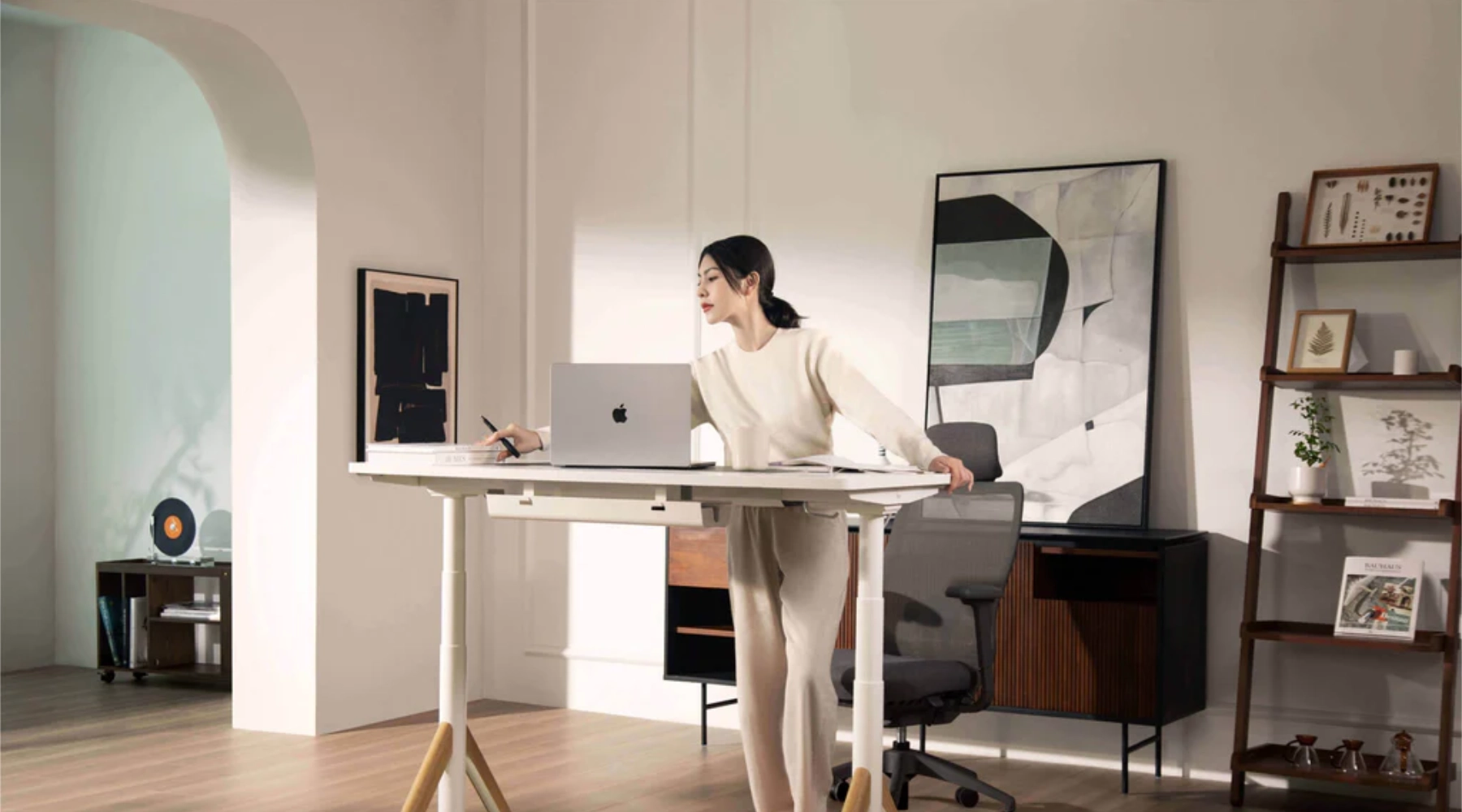 Person working at a modern standing desk in a minimalist home office workspace